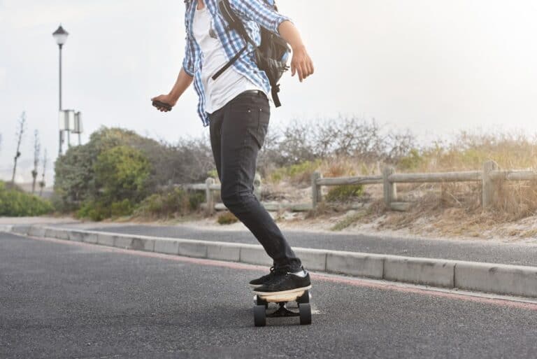 boy cruising on electric skateboard on street