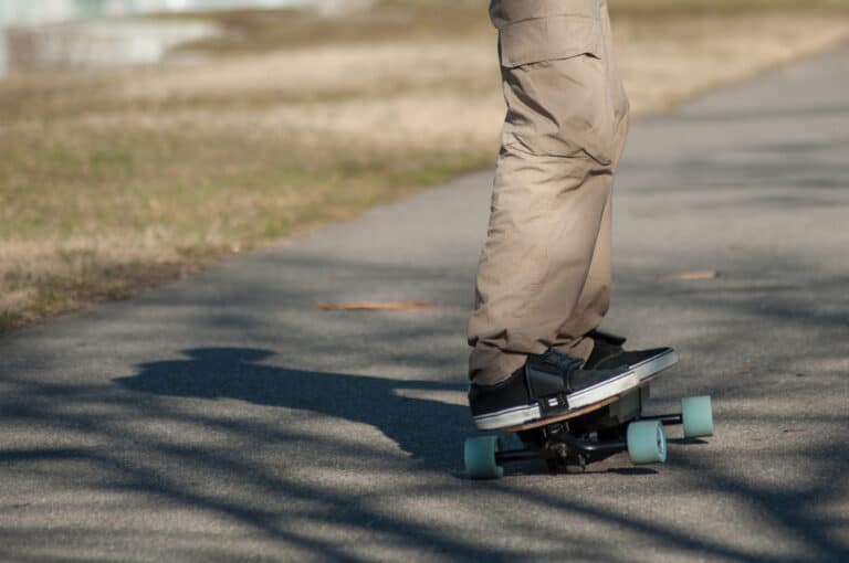 close up of man standing on electric skateboard