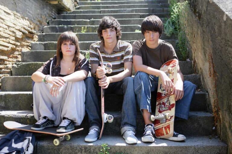 kids sitting on step with their skateboards having fun