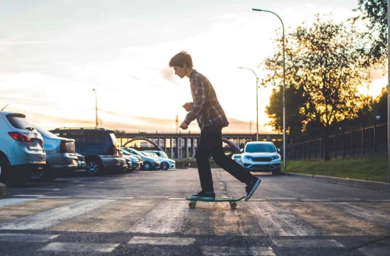 boy skating across the road on a skateboard