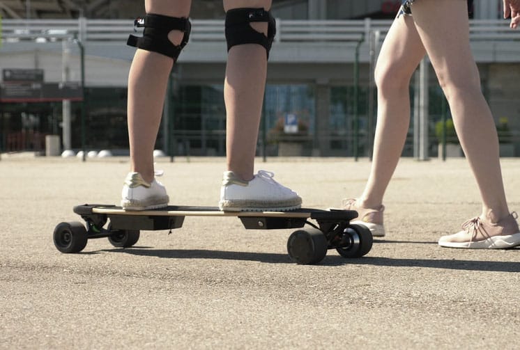 close up of girl standing on an electric skateboard